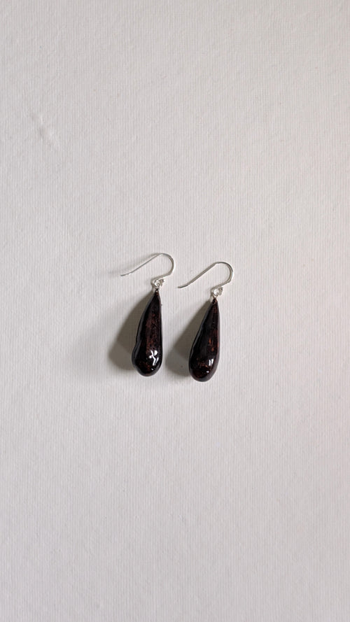 Teardrop shaped handmade ceramic earrings painted in chocolate brown and finished with sterling silver ear wires.