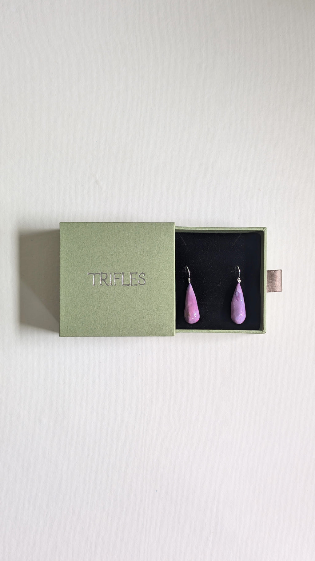 Teardrop shaped handmade ceramic earrings painted in chocolate brown and finished with sterling silver ear wires in Trifles gift box.
