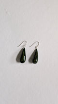 Teardrop shaped handmade ceramic earrings painted in olive green and finished with sterling silver ear wires.