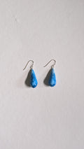 Teardrop shaped handmade ceramic earrings painted in sky blue and finished with sterling silver ear wires.