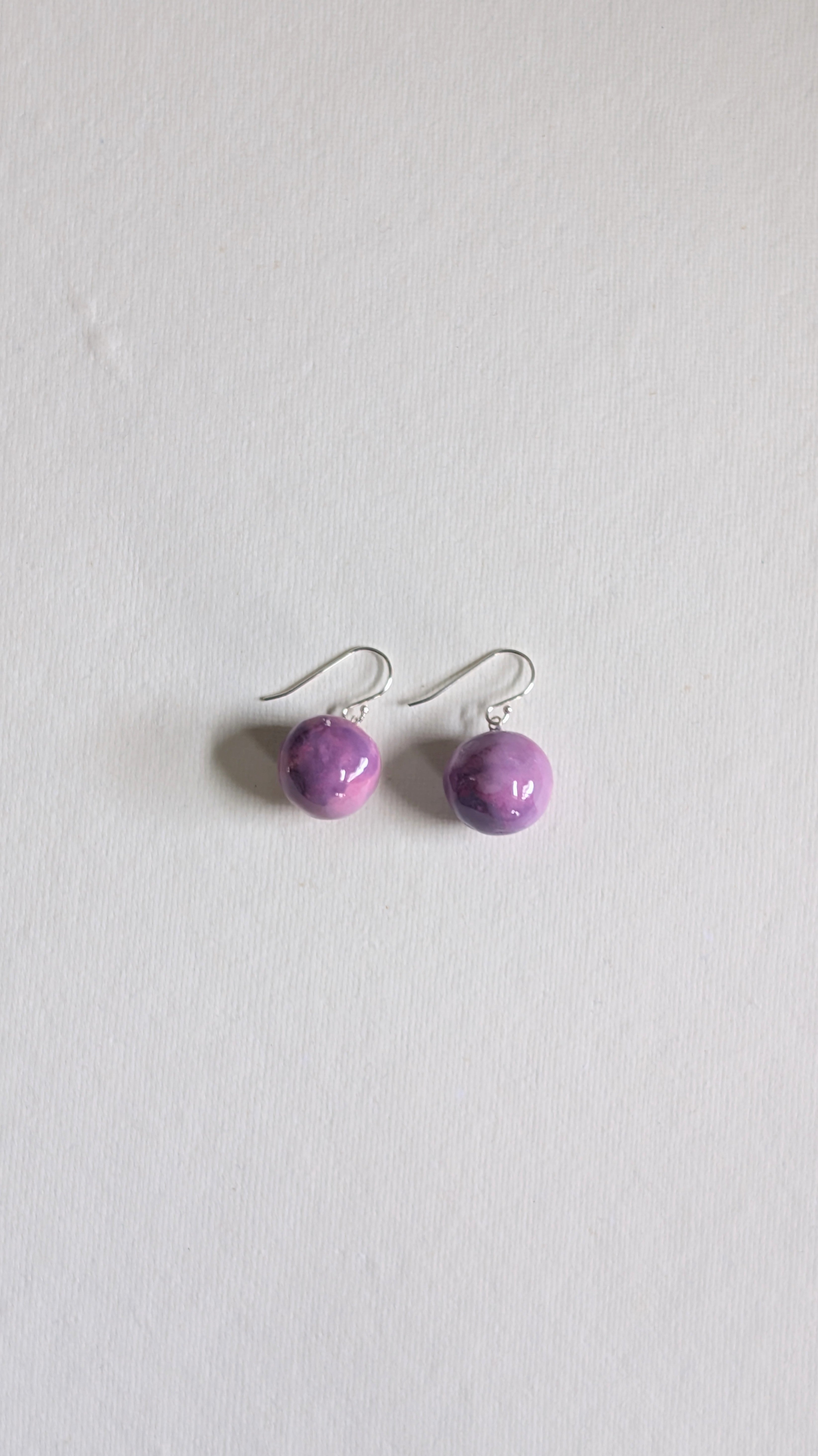 Handmade ceramic orb shaped earrings in lilac with sterling silver ear wires.