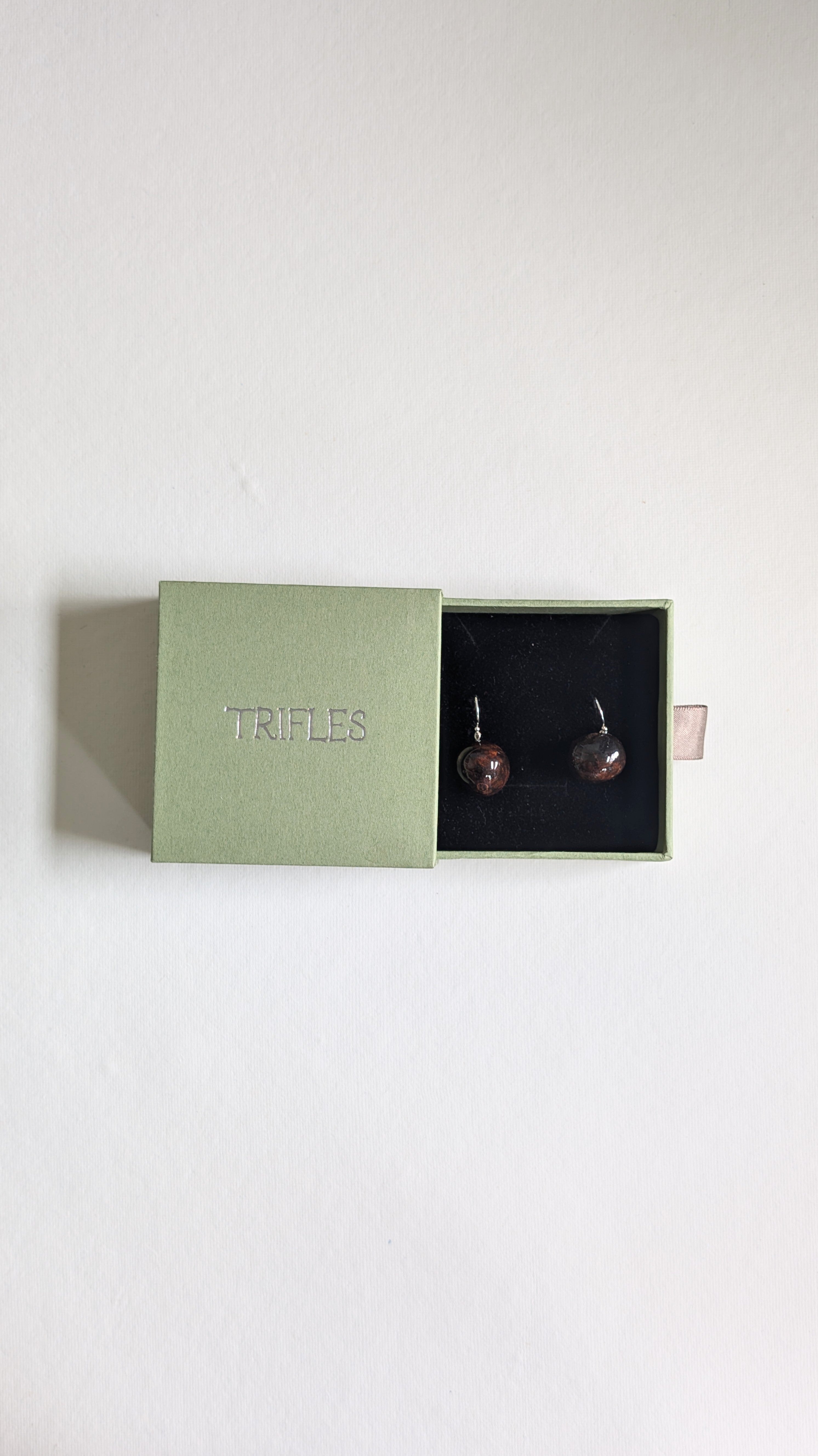 Hand painted ceramic orb earrings in chocolate brown with sterling silver ear wires in Trifles gift box.