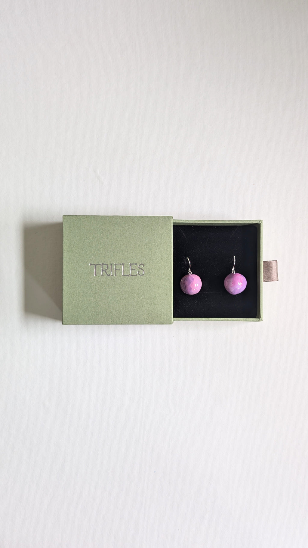 Handmade ceramic orb shaped earrings in lilac with sterling silver ear wires in Trifles gift box.