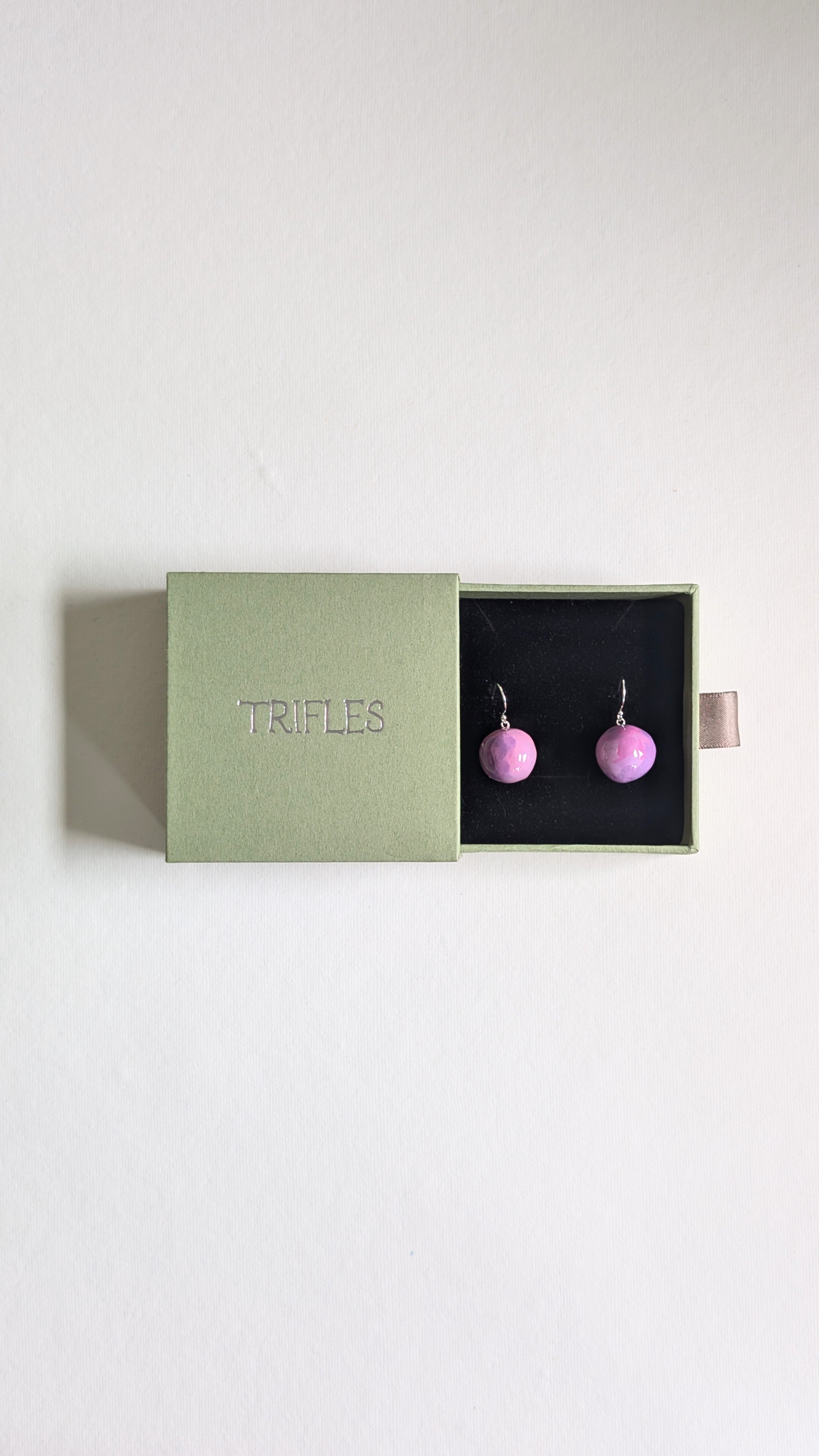 Handmade ceramic orb shaped earrings in lilac with sterling silver ear wires in Trifles gift box.