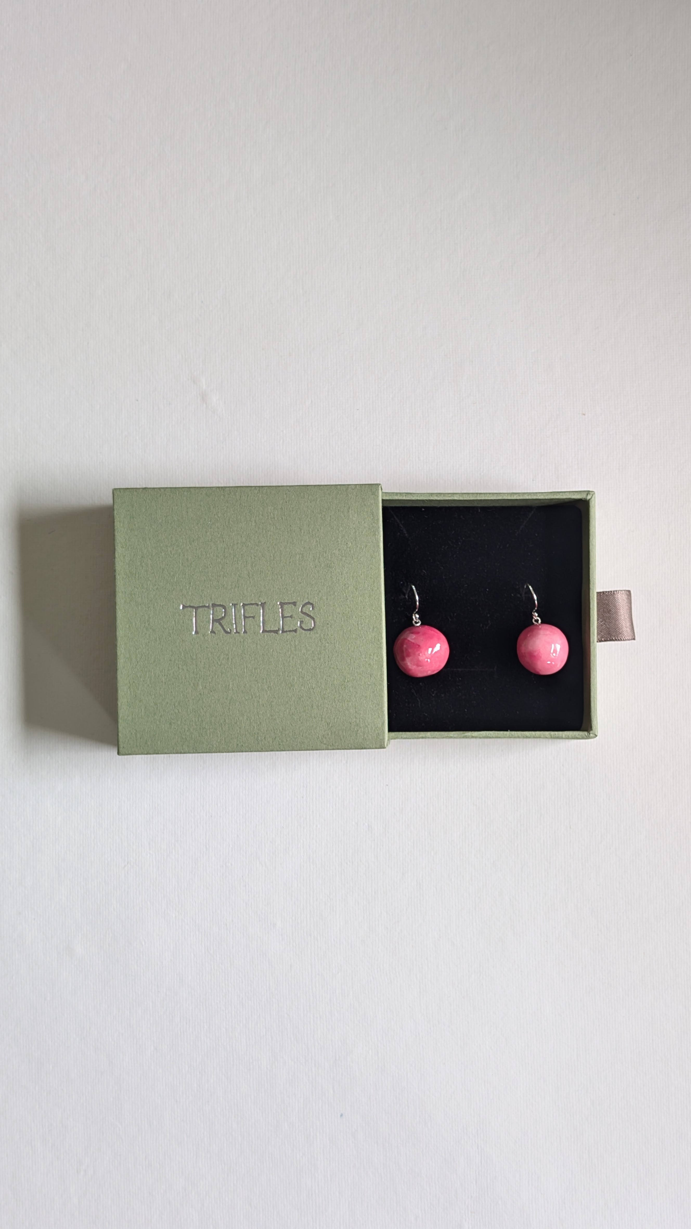 Orb shaped handmade ceramic earrings painted in sky blue and finished with sterling silver ear wires in Trifles gift box.