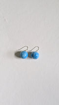 Orb shaped handmade ceramic earrings painted in sky blue and finished with sterling silver ear wires.