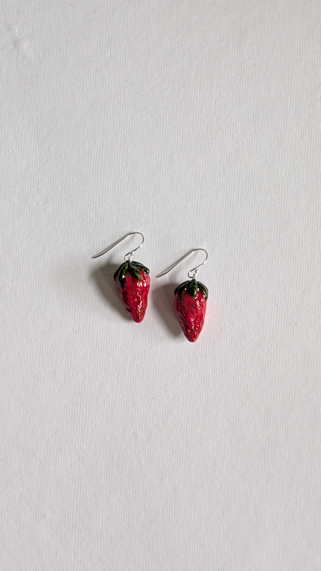 Hand painted ceramic strawberry earrings with sterling silver ear wires.