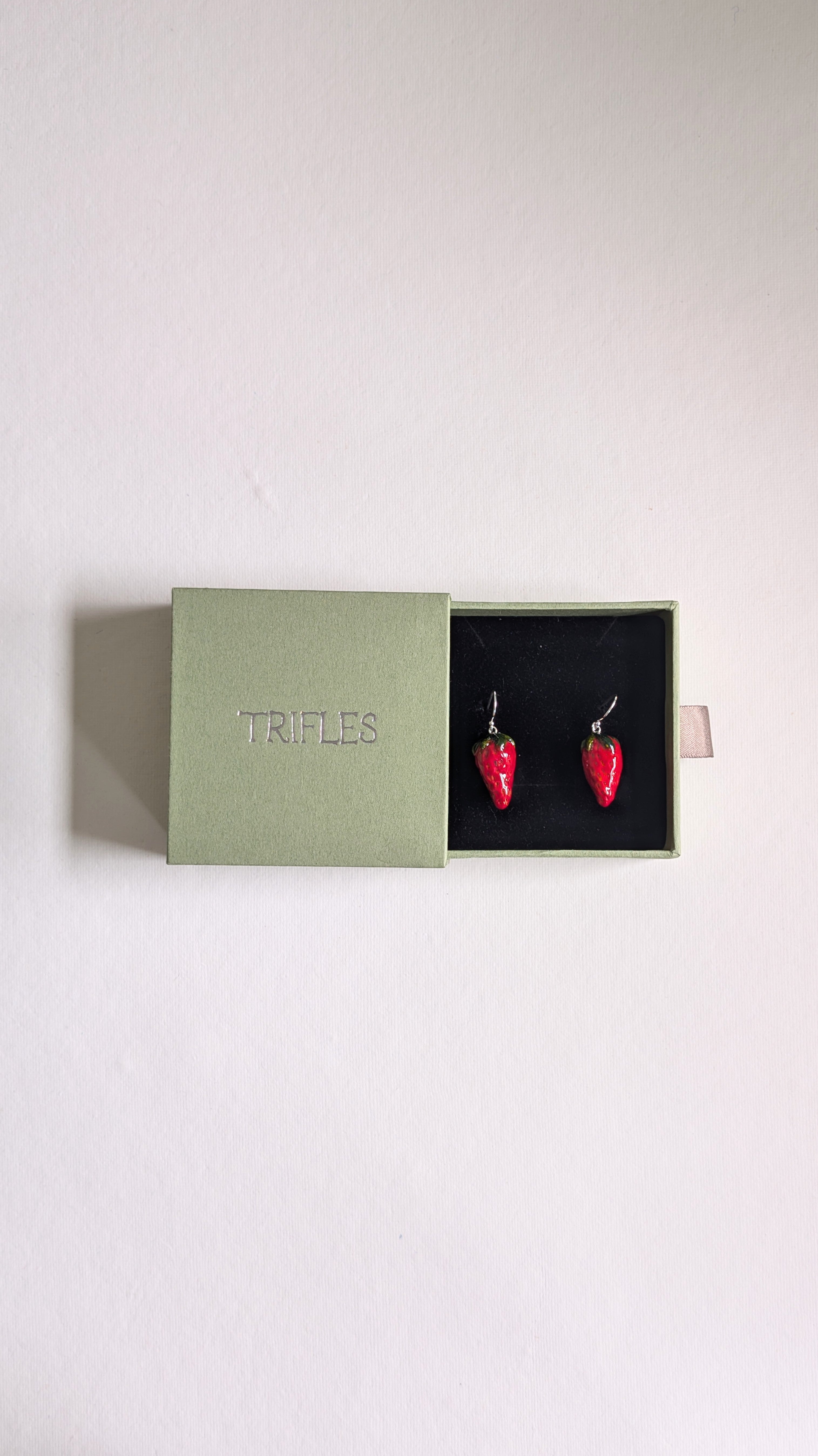 Hand painted ceramic strawberry earrings with sterling silver ear wires in Trifles gift box.