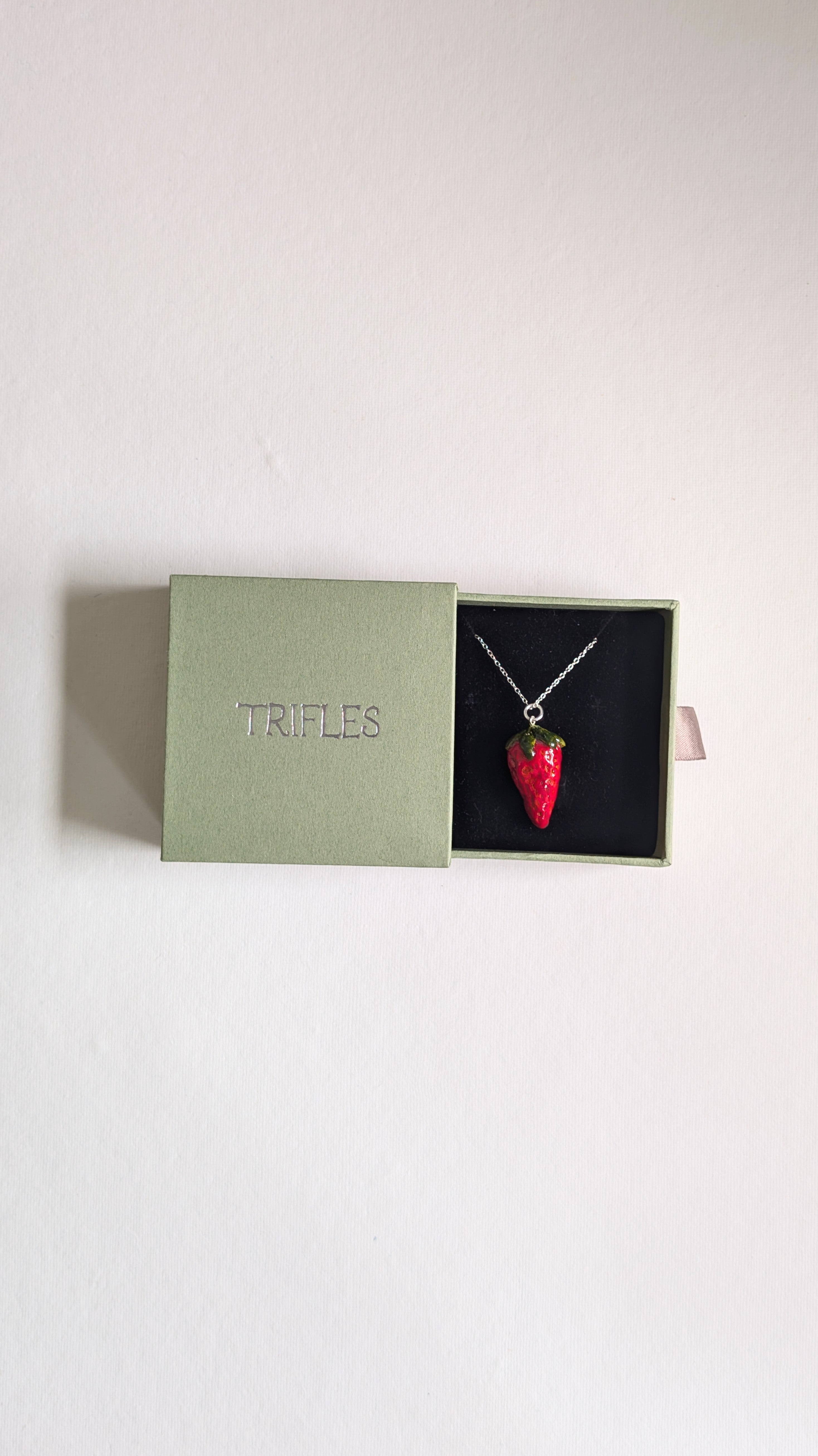 Hand painted ceramic strawberry necklace on sterling silver chain in a Trifles gift box.